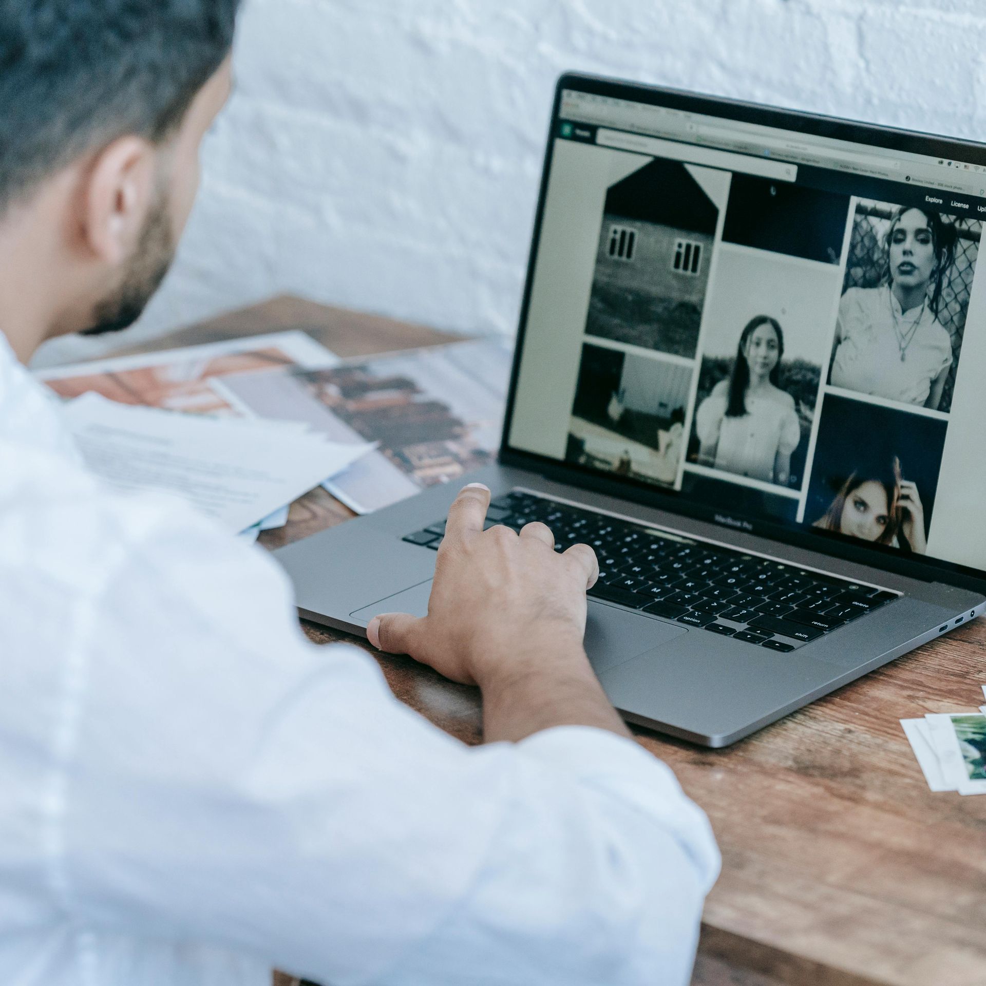 Indian photographer reviewing website builder options on a laptop with a checklist