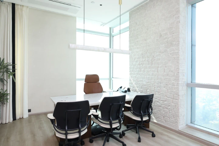 A clean and minimal meeting space reflecting the calm, executive design language of the office Calm executive meeting room with natural light in a modern corporate office, photographed by Ranjan Bhattacharya