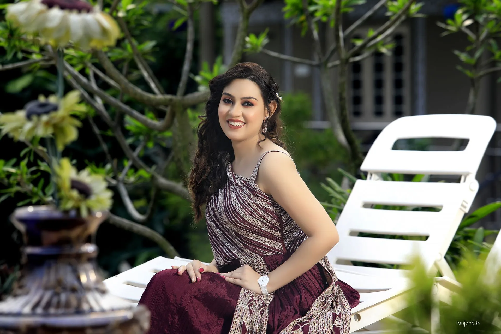 Best Portrait Photography - Lady in Maroon Dress Outdoors by Ranjan Bhattacharya Elegant portrait of a lady in a maroon dress seated outdoors, captured by Ranjan Bhattacharya, showcasing natural beauty and serene environment.