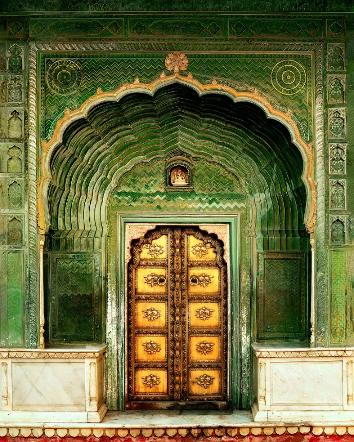 A majestic view of golden wooden door on green concrete building, photography by Ranjan Bhattacharya