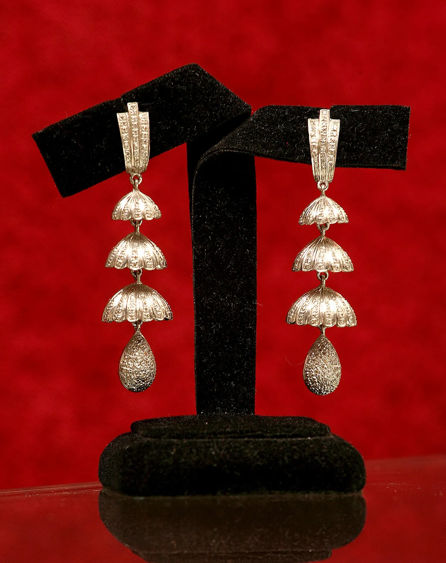 Detailed shot of earrings on a display stand, creative backdrop.