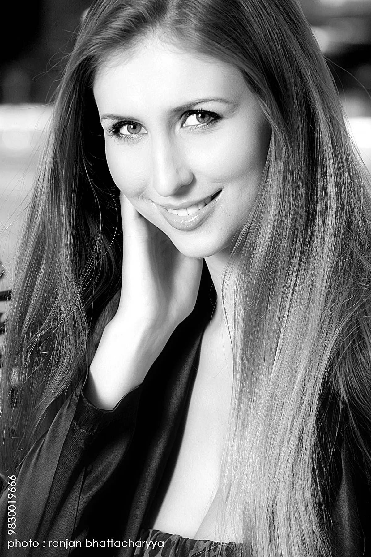 Claudia Ciesla, A Smiling Bollywood Actress, a portrait by acclaimed photographer Ranjan Bhattacharya Claudia Ciesla, a Bollywood actress, smiles with her hand on her chin in a portrait by renowned photographer Ranjan Bhattacharya.