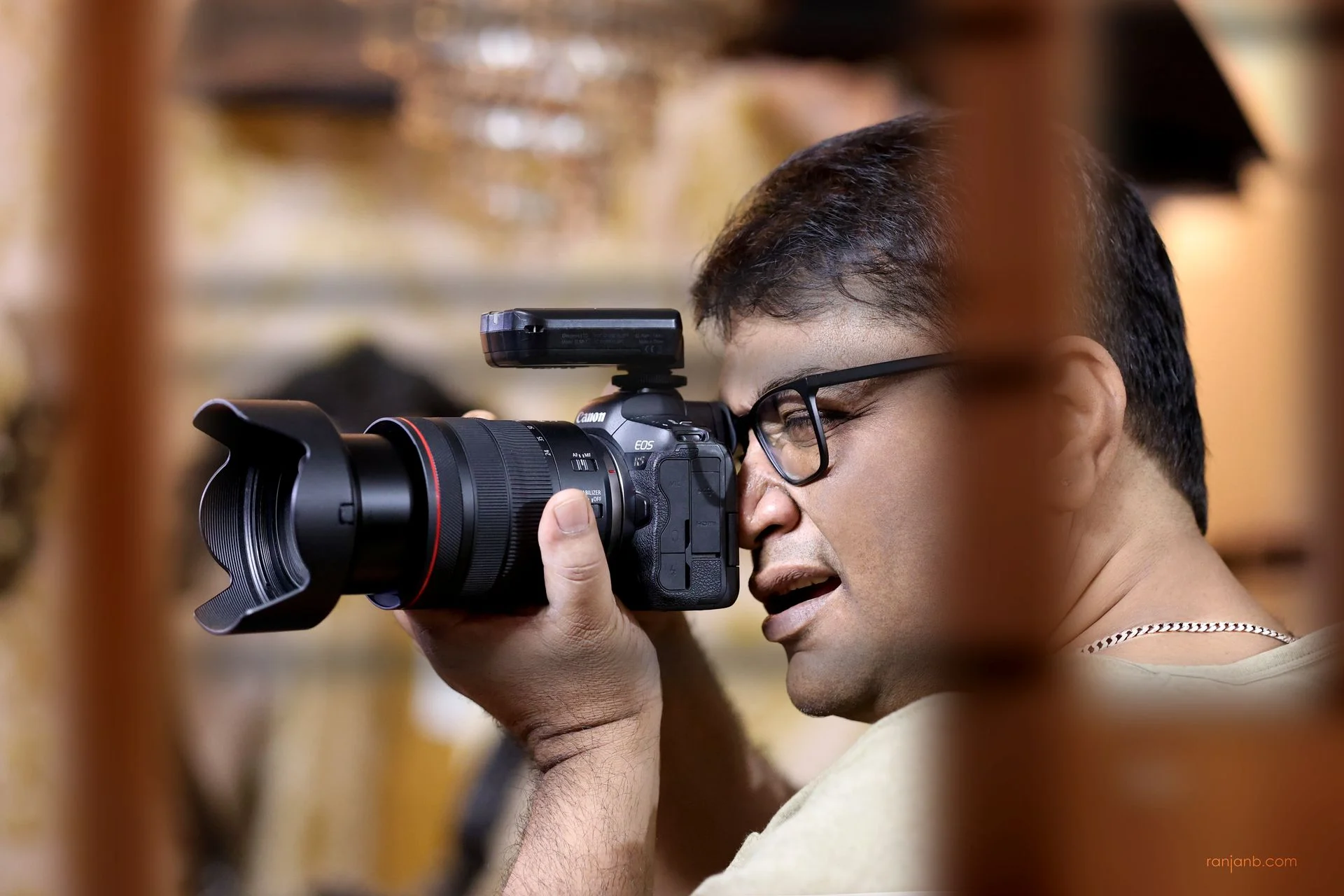 Ranjan Bhattacharya, advertising photographer and author, holding a camera at eye level ready to shoot — based in Kolkata, India
