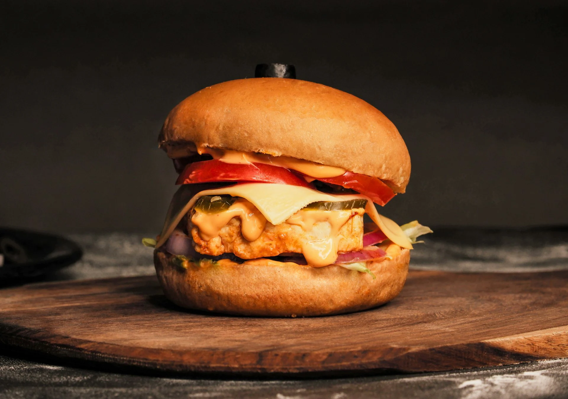 A cheeseburger on a wooden surface, photographed by Ranjan Bhattacharya