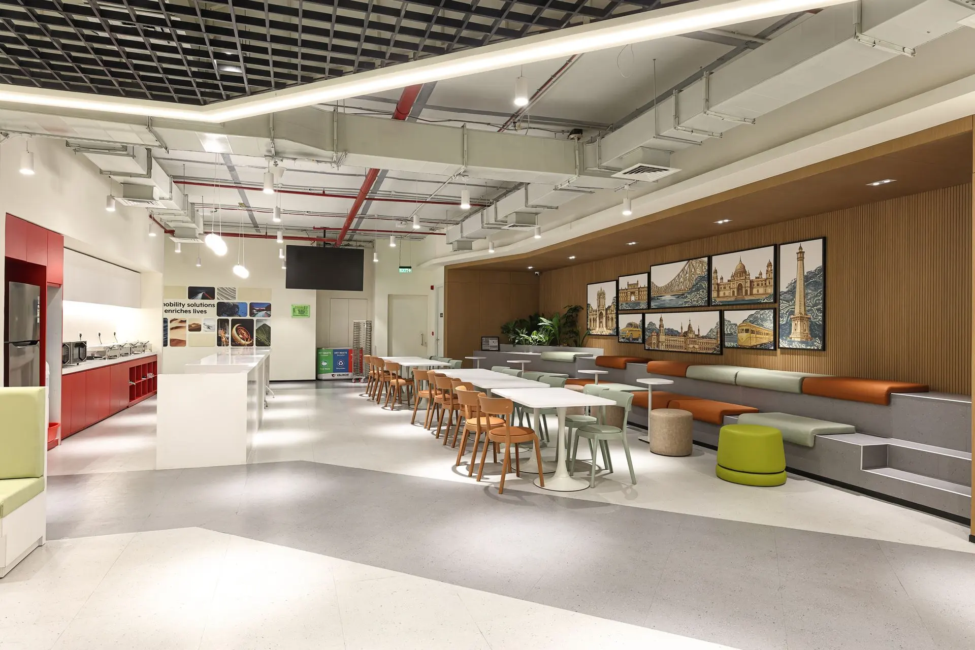 Commercial interior photography of a modern corporate office cafeteria featuring a collaborative breakout lounge, coffee station, contemporary seating and workplace interior design.