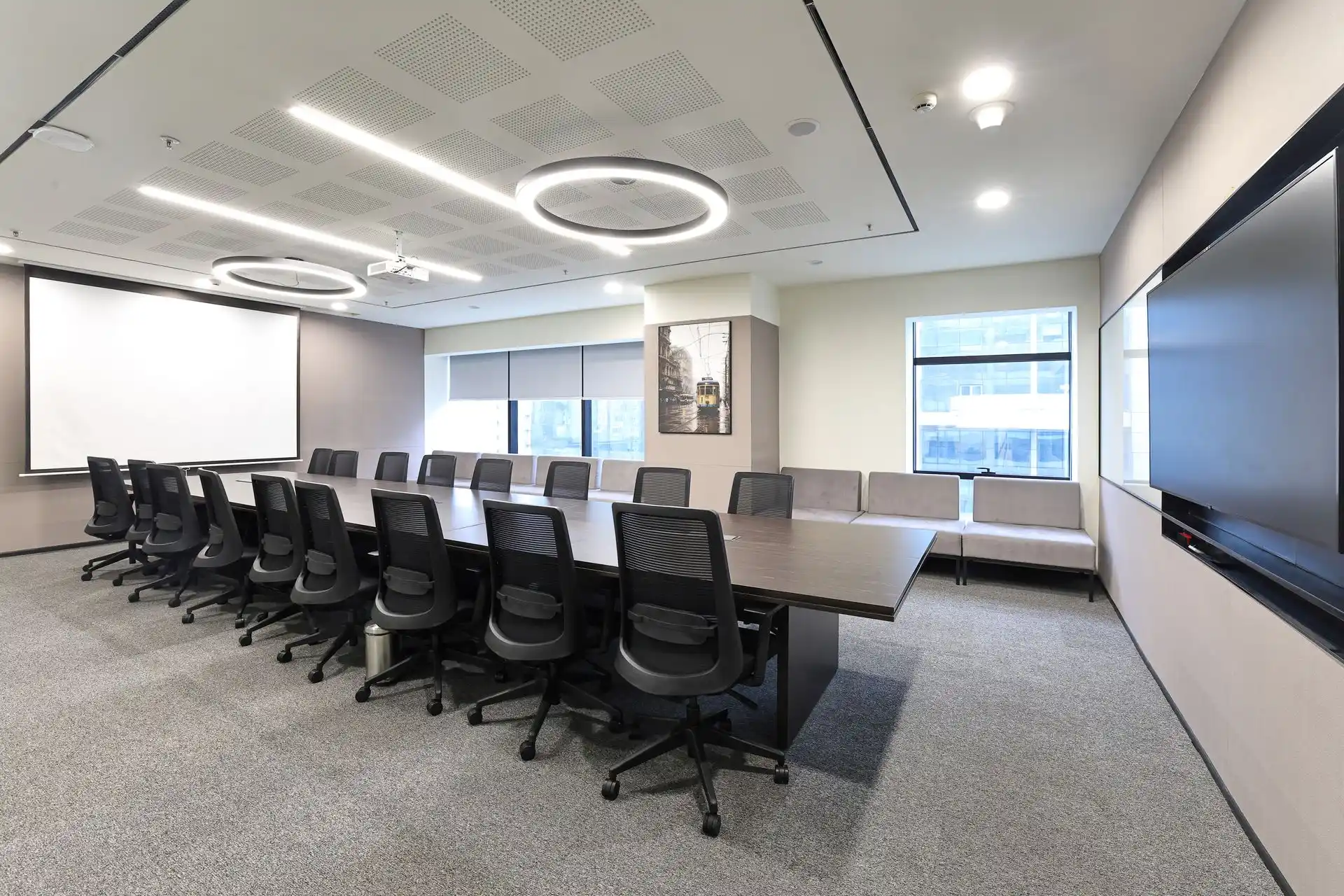 Commercial interior photography of an executive boardroom featuring a modern conference table, ergonomic seating, presentation display and contemporary corporate office design.