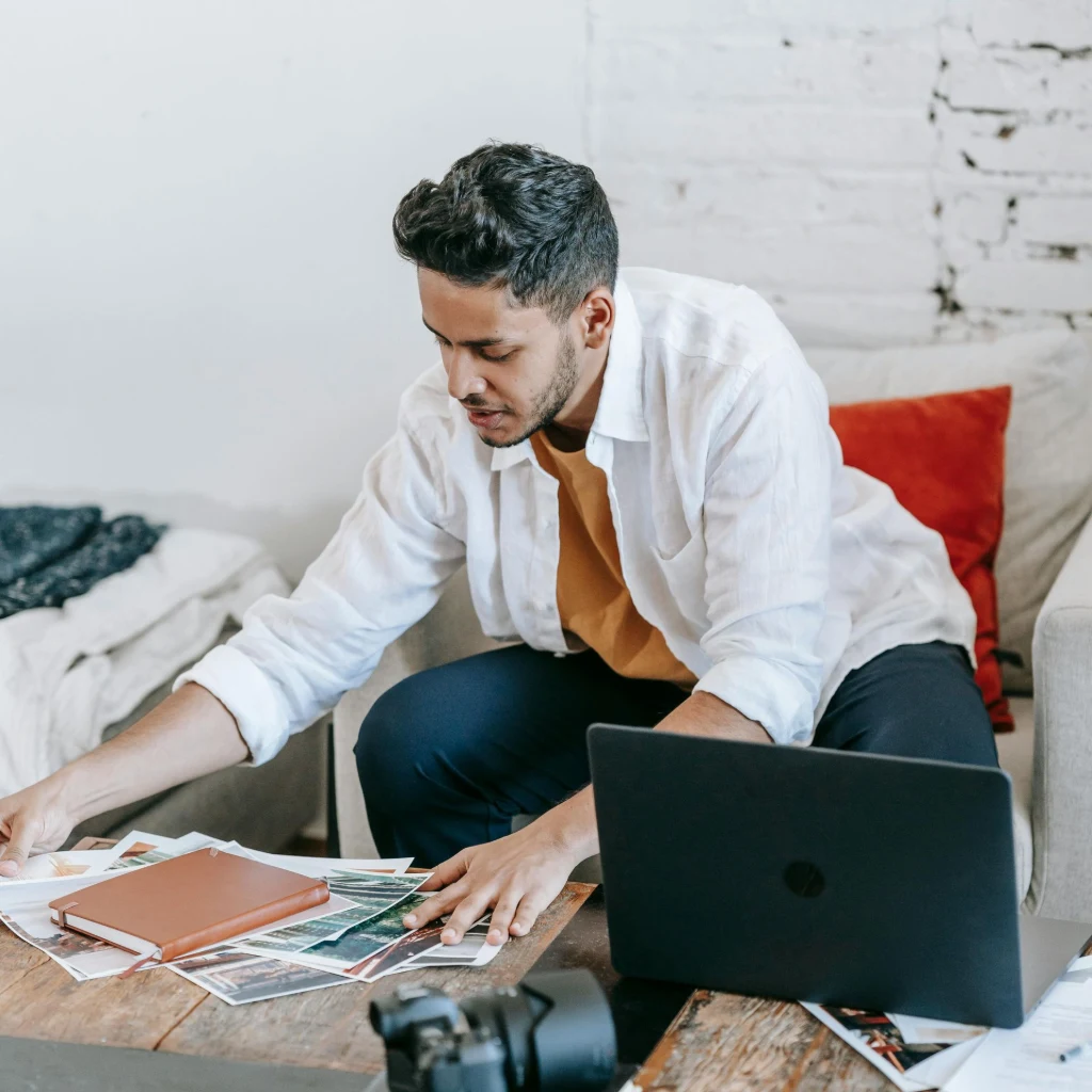 Indian photographer confidently reviewing finished website on laptop in a creative workspace