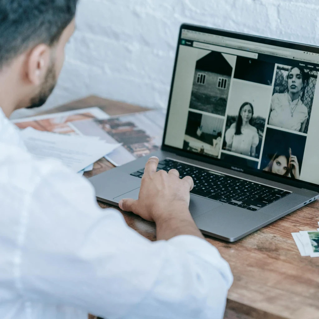 Indian photographer reviewing website builder options on a laptop with a checklist