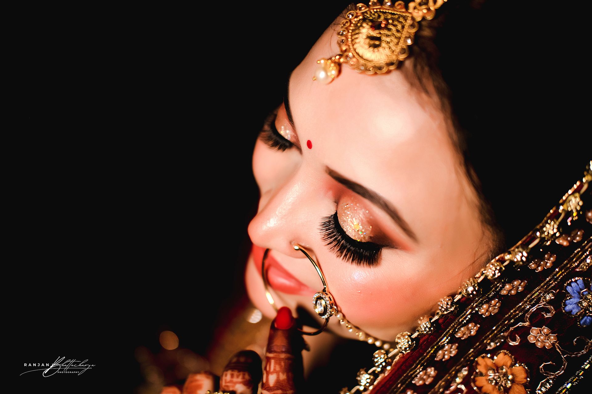 A candid moment from Ruhi Singh's wedding, while doing her bridal makeup, photographed by the best wedding photographer in Kolkata - Ranjan Bhattacharya