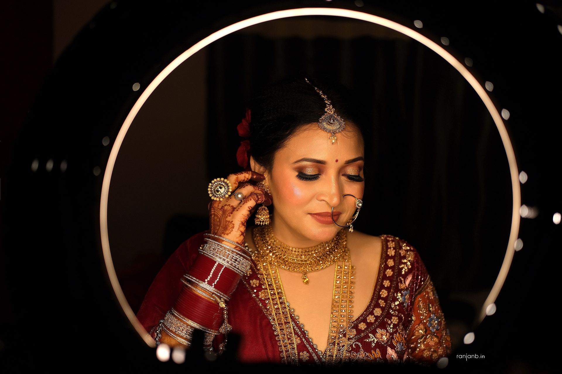 A candid moment from Ruhi Singh's wedding, while doing her bridal makeup, photographed by the best wedding photographer in Kolkata - Ranjan Bhattacharya