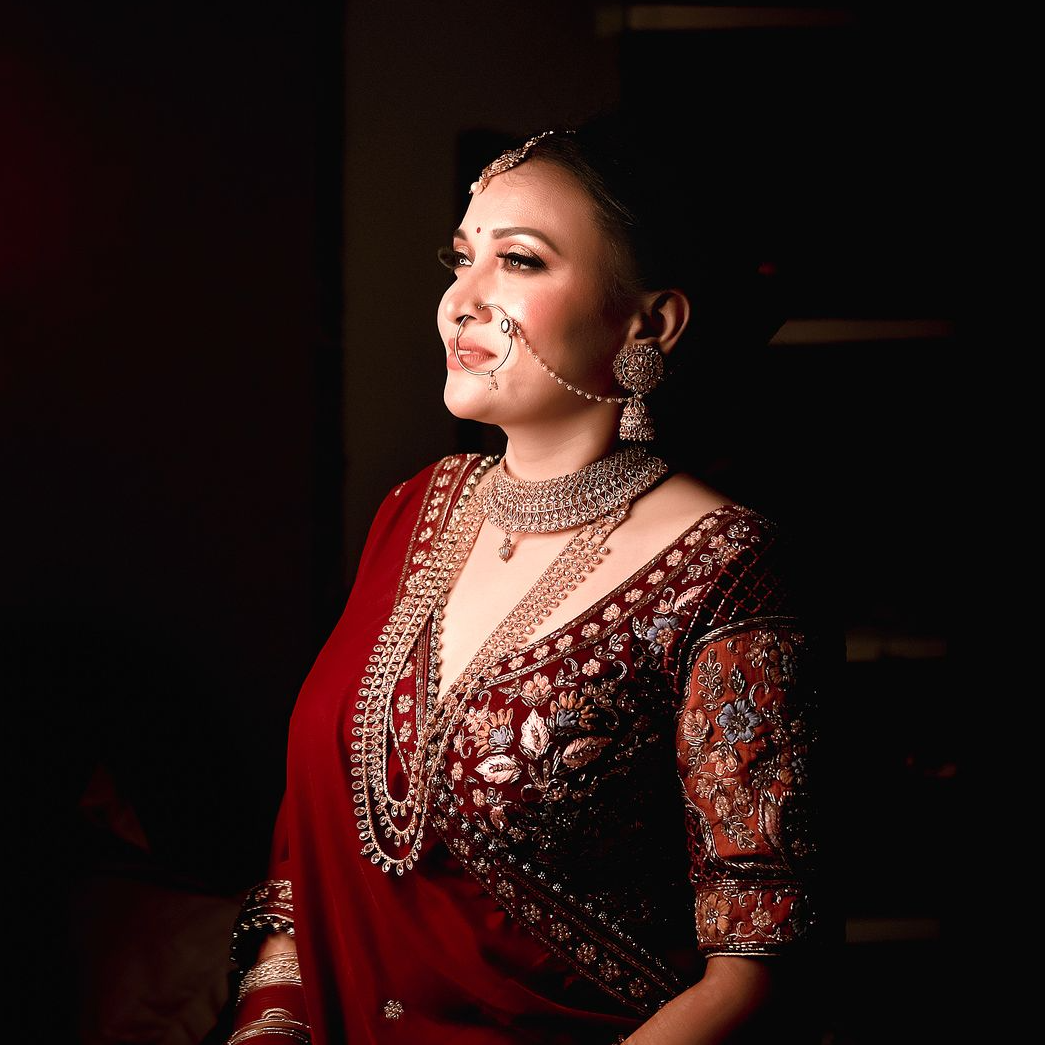 A candid moment from Ruhi Singh's wedding, while doing her bridal makeup, photographed by the best wedding photographer in Kolkata - Ranjan Bhattacharya