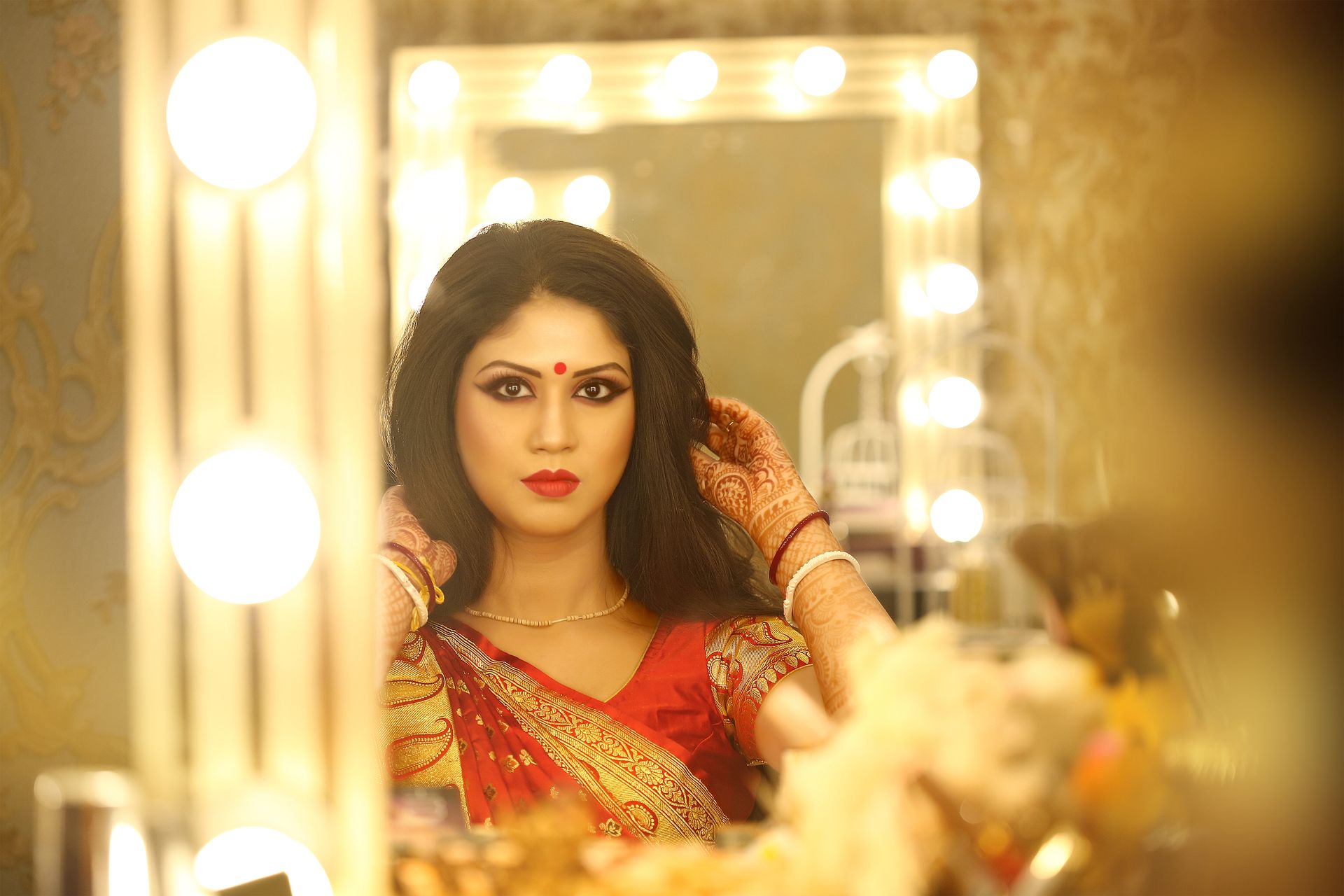 A candid moment from Debarati Sarkar's wedding, while doing her bridal makeup, photographed by the best wedding photographer in Kolkata - Ranjan Bhattacharya