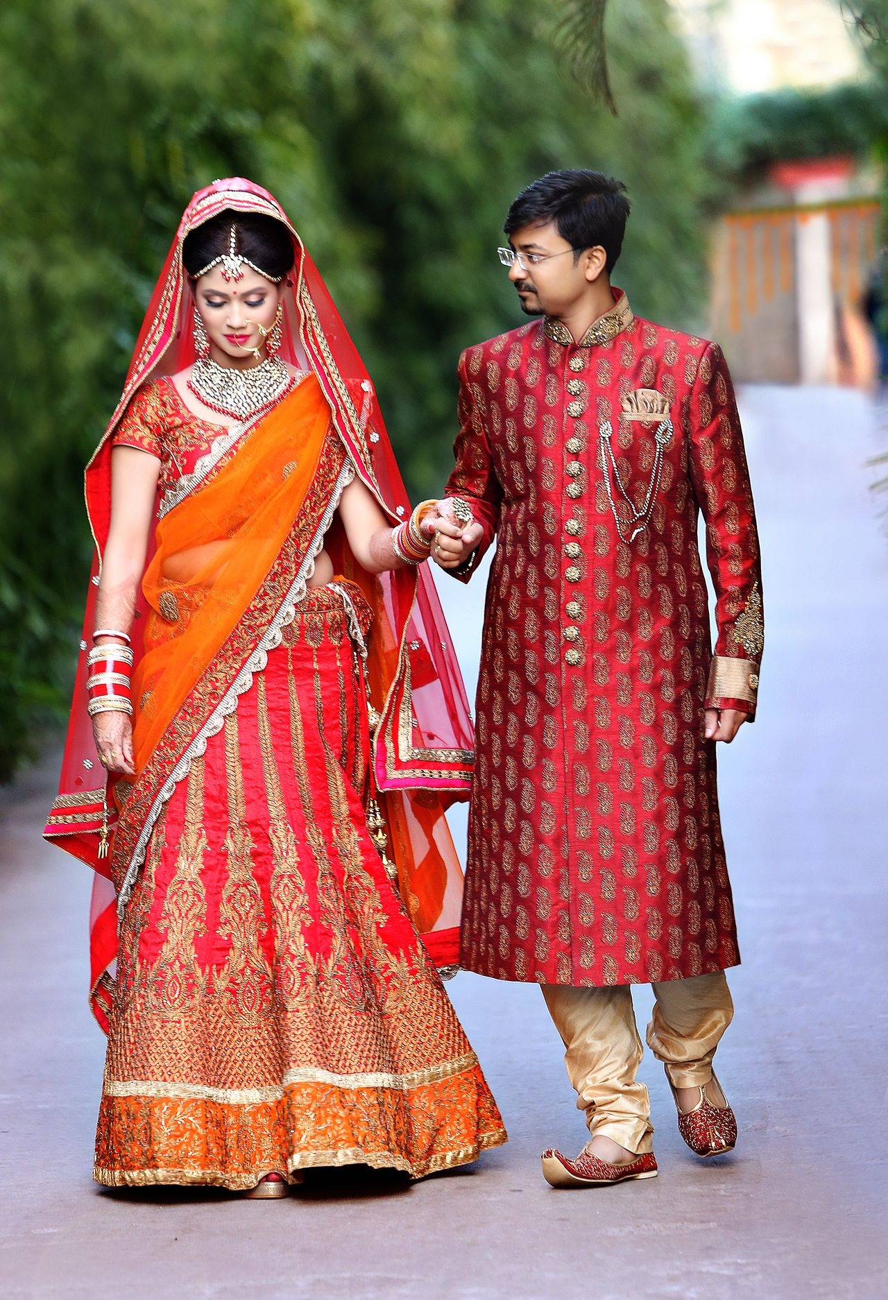 Bride and Groom Walking by holding their hands passionately, Wedding Photography by the Best Wedding Photographer in Kolkata - Ranjan Bhattacharya