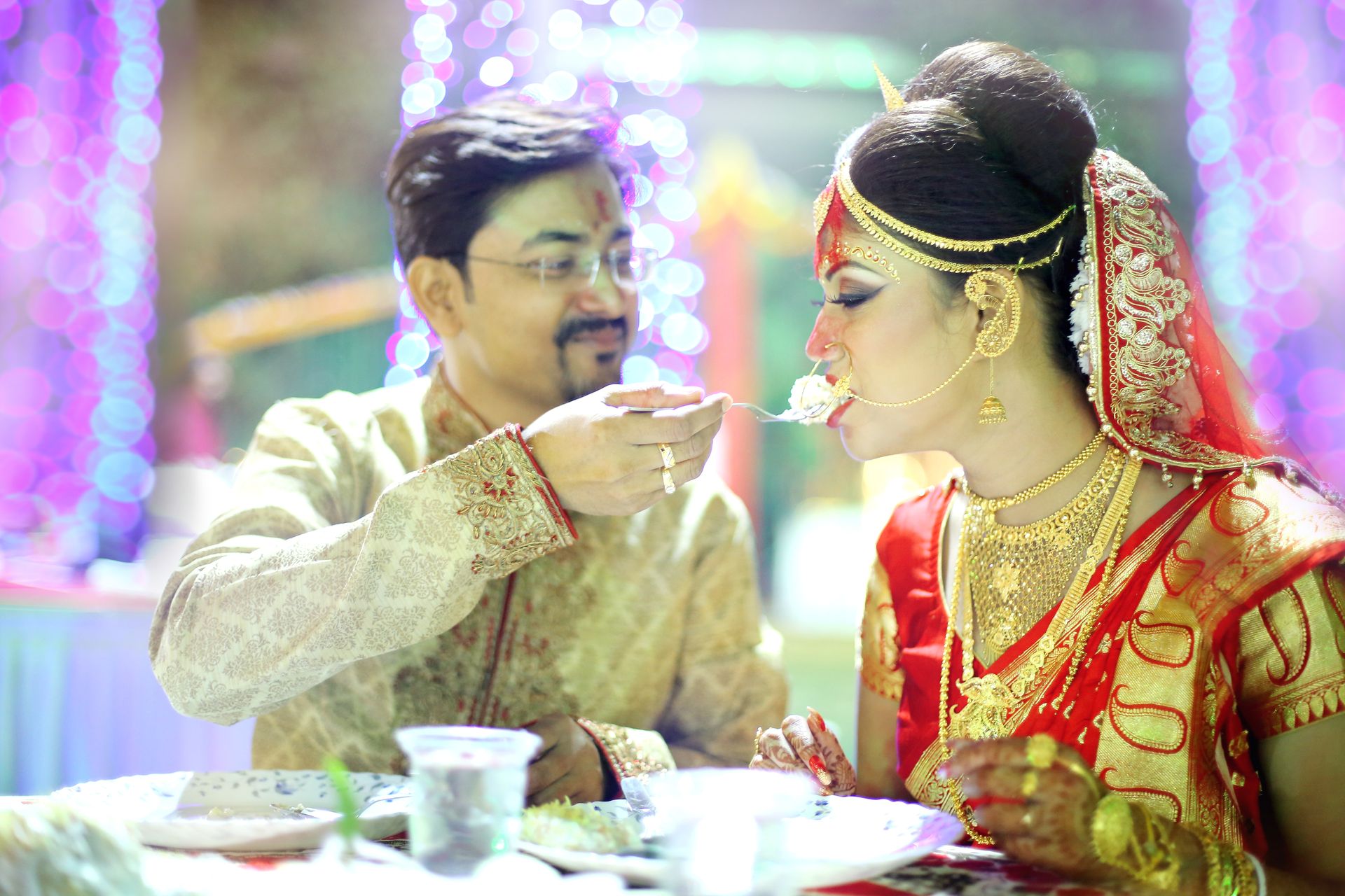 Candid shot of the bride and groom sharing a laugh during their wedding dinner.
